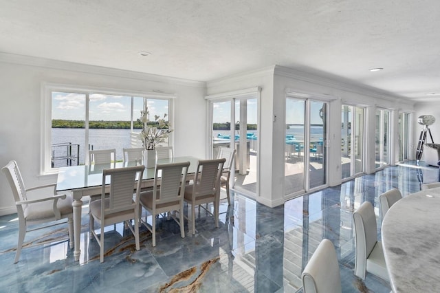 dining area featuring a water view, ornamental molding, and a textured ceiling