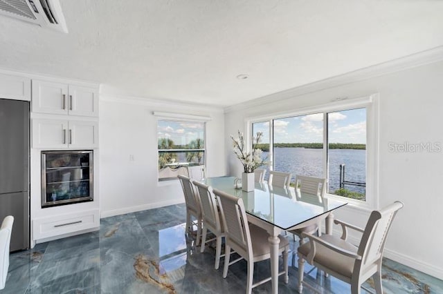 dining space with wine cooler, crown molding, visible vents, a water view, and baseboards