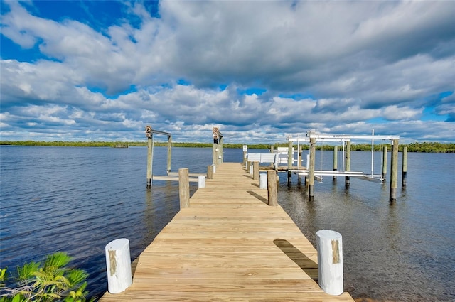 dock area with a water view and boat lift