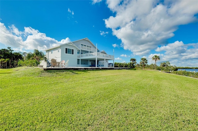 rear view of house featuring a yard and a deck with water view