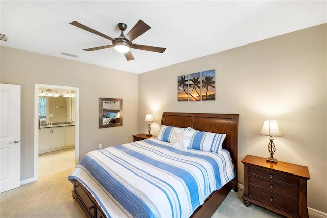 bedroom featuring ensuite bathroom, a ceiling fan, visible vents, and light colored carpet