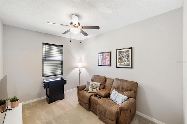 living room featuring light carpet, baseboards, and a textured ceiling