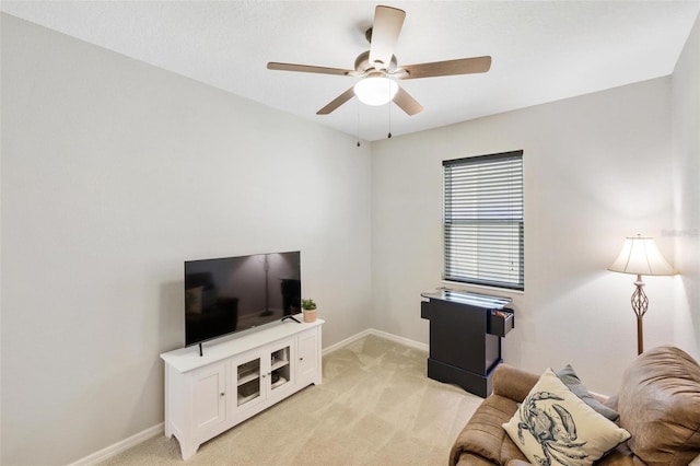 living room with ceiling fan, baseboards, and light colored carpet