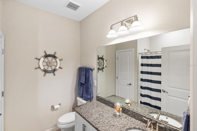 bathroom with curtained shower, toilet, visible vents, vanity, and baseboards