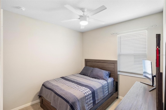 bedroom featuring light carpet, a ceiling fan, and baseboards