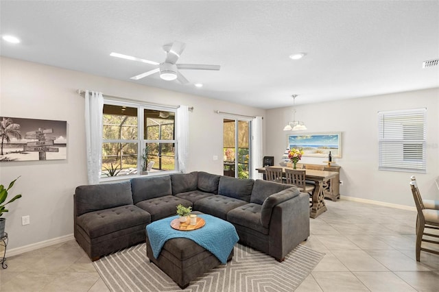 living area with light tile patterned floors, a textured ceiling, recessed lighting, and baseboards