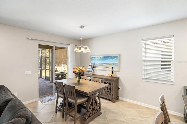 dining space featuring light tile patterned floors, baseboards, and an inviting chandelier