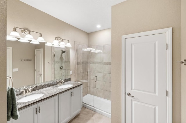 full bath featuring a stall shower, double vanity, a sink, and tile patterned floors