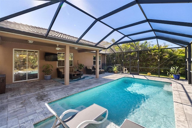 outdoor pool with glass enclosure, a patio area, and a ceiling fan