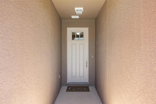 property entrance with visible vents and stucco siding