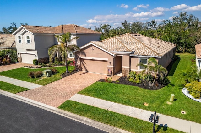 view of front facade featuring a tile roof, stone siding, decorative driveway, stucco siding, and a front yard