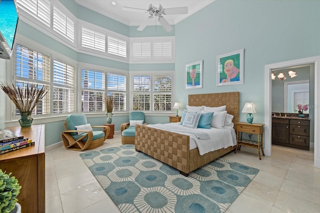 bedroom featuring light tile patterned floors, ensuite bathroom, a high ceiling, baseboards, and crown molding