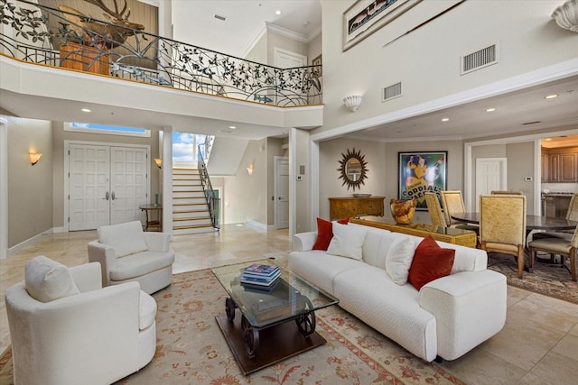 living area featuring baseboards, stairs, visible vents, and ornamental molding