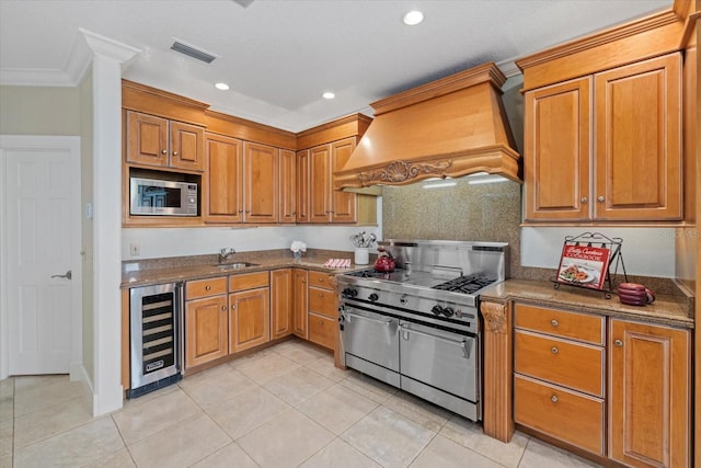 kitchen with wine cooler, stainless steel appliances, premium range hood, visible vents, and brown cabinetry