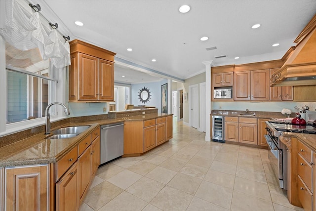 kitchen with wine cooler, stainless steel appliances, ornamental molding, a sink, and dark stone counters