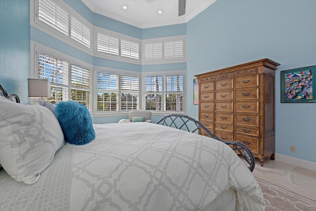 bedroom with a high ceiling, multiple windows, ceiling fan, and baseboards