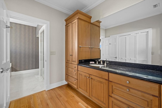 bathroom with vanity, visible vents, crown molding, and wood finished floors