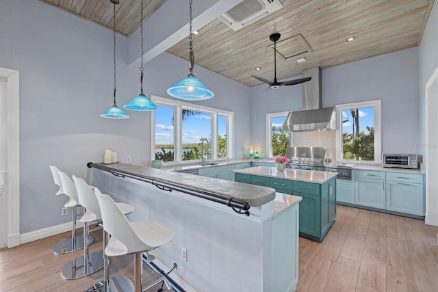 kitchen with a toaster, light wood finished floors, wood ceiling, and a breakfast bar area