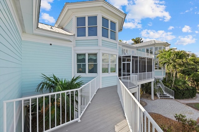 back of property with metal roof and a sunroom