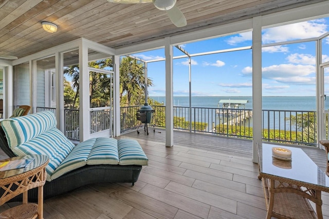 sunroom / solarium with a water view, wooden ceiling, and a ceiling fan