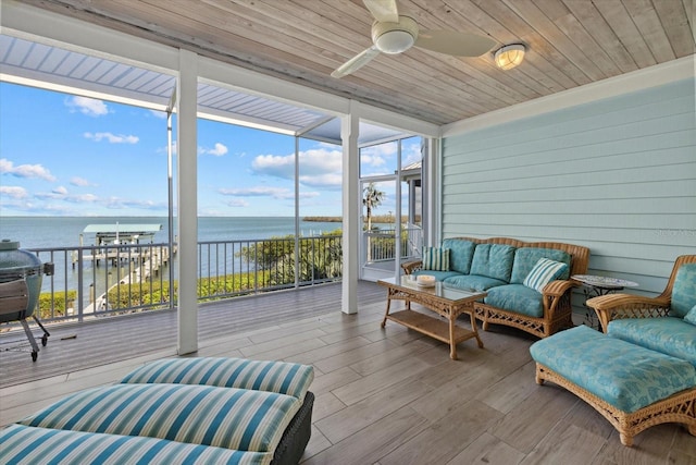 sunroom featuring a water view, wood ceiling, and ceiling fan