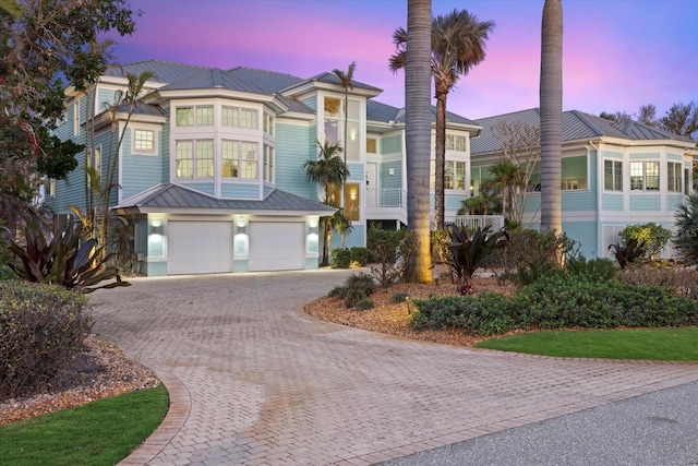 view of front of property featuring a garage, decorative driveway, and metal roof