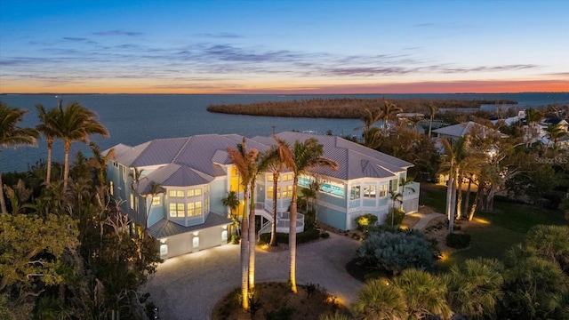 aerial view at dusk featuring a water view