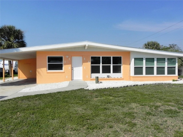 rear view of property with an attached carport and a yard