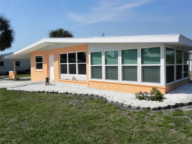 rear view of property featuring brick siding and a yard