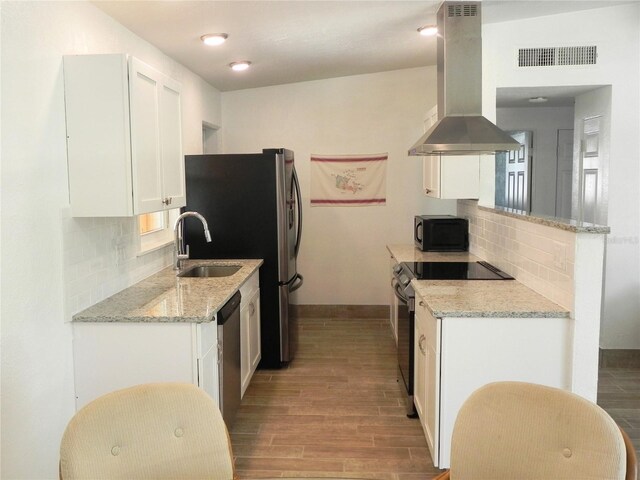 231 Redwood Rd, Venice, FL 34293 - kitchen with appliances with stainless steel finishes, light wood-style floors, visible vents, and island range hood