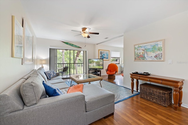 living area featuring visible vents, wood finished floors, a ceiling fan, and baseboards