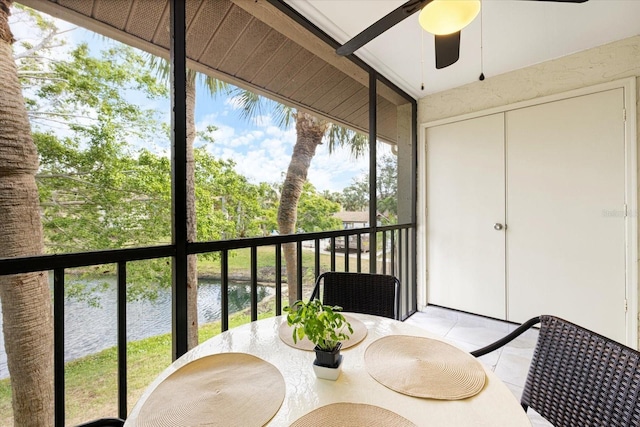 sunroom / solarium with a water view, plenty of natural light, and ceiling fan