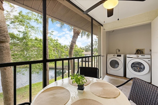 sunroom / solarium featuring ceiling fan, independent washer and dryer, and a water view