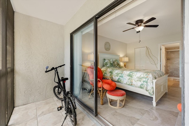 bedroom with a textured wall and ceiling fan