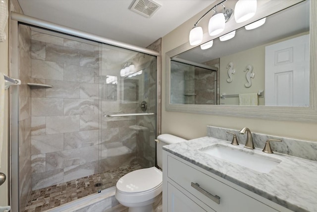 full bath with toilet, a stall shower, vanity, and visible vents