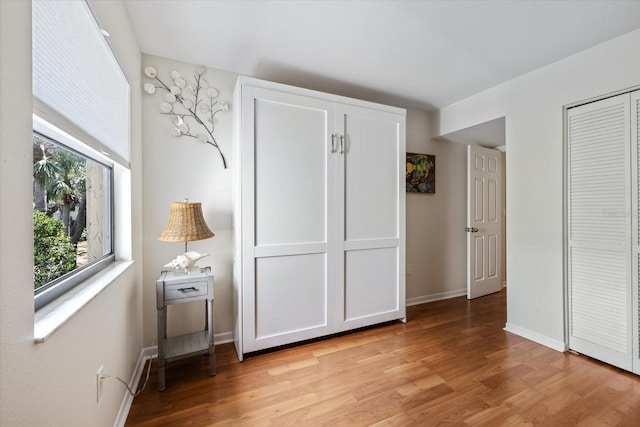 unfurnished bedroom with light wood-style floors and baseboards