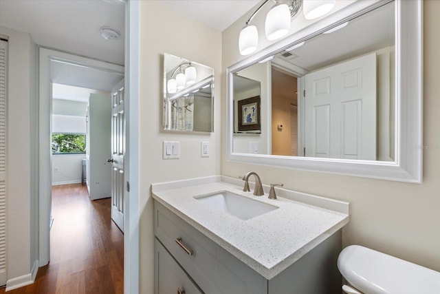 bathroom with vanity, toilet, and wood finished floors