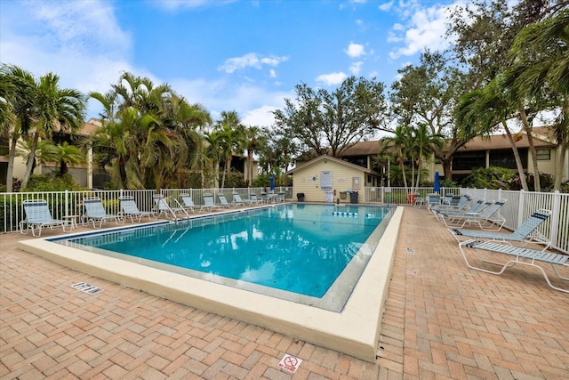 pool with a patio and fence