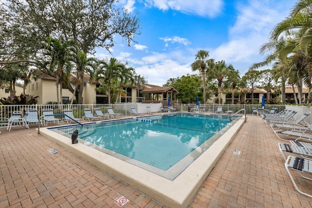 community pool with fence and a patio