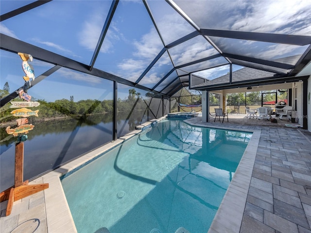 outdoor pool with a patio area, a water view, and a lanai