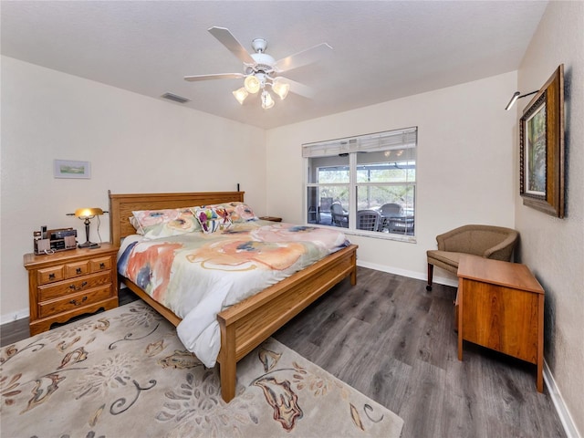 bedroom with visible vents, baseboards, and wood finished floors