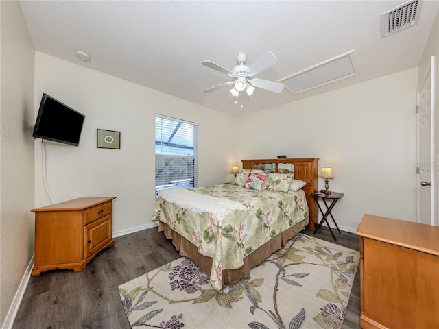 bedroom featuring visible vents, attic access, ceiling fan, wood finished floors, and baseboards