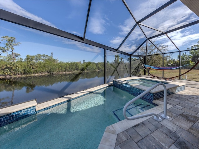 view of pool with a patio area, a water view, a lanai, and a pool with connected hot tub