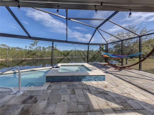 view of pool with a patio area, a lanai, a water view, and an in ground hot tub