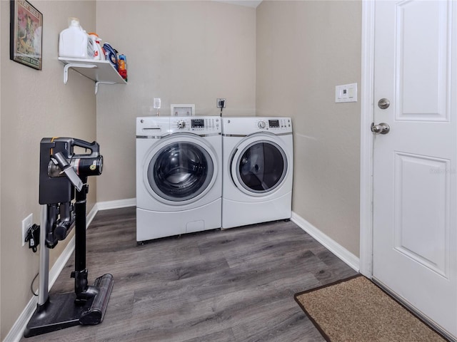 laundry room with laundry area, baseboards, washer and clothes dryer, and wood finished floors