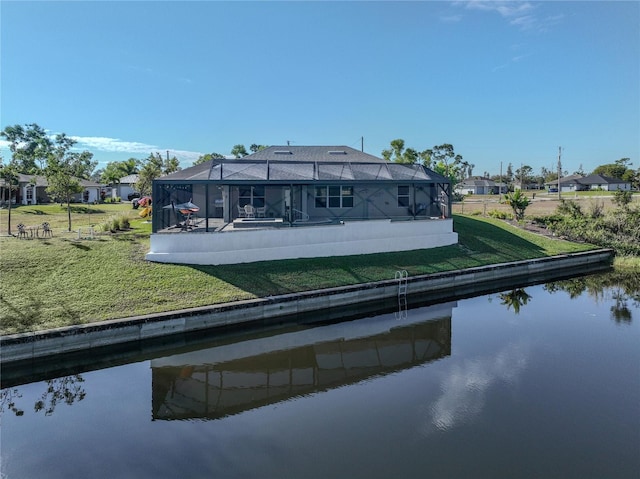 back of house with a lanai, a water view, and a lawn