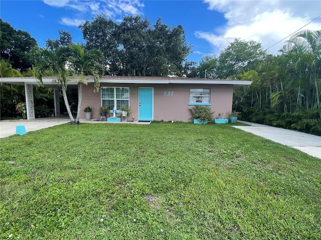 ranch-style home with a carport, concrete driveway, and a front yard