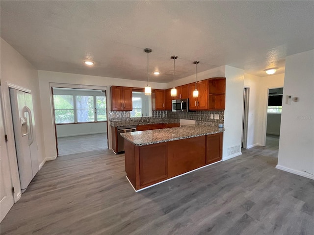 kitchen with dark wood-style flooring, appliances with stainless steel finishes, backsplash, open shelves, and brown cabinetry