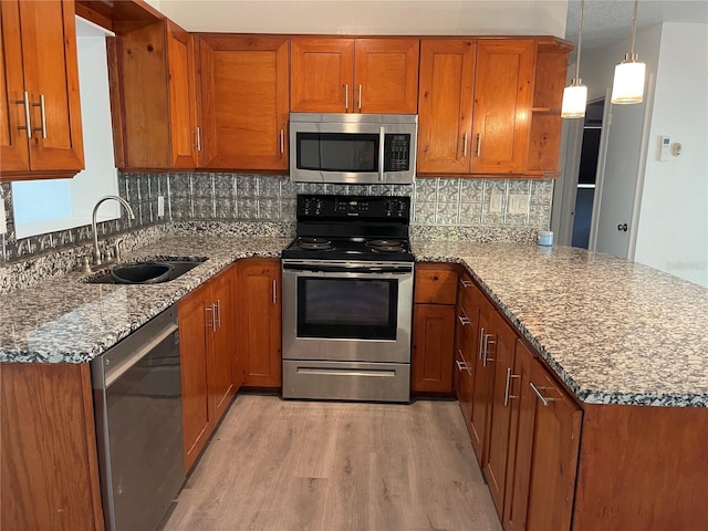 kitchen featuring appliances with stainless steel finishes, brown cabinetry, and a sink