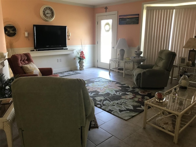 living room with a wainscoted wall and tile patterned flooring